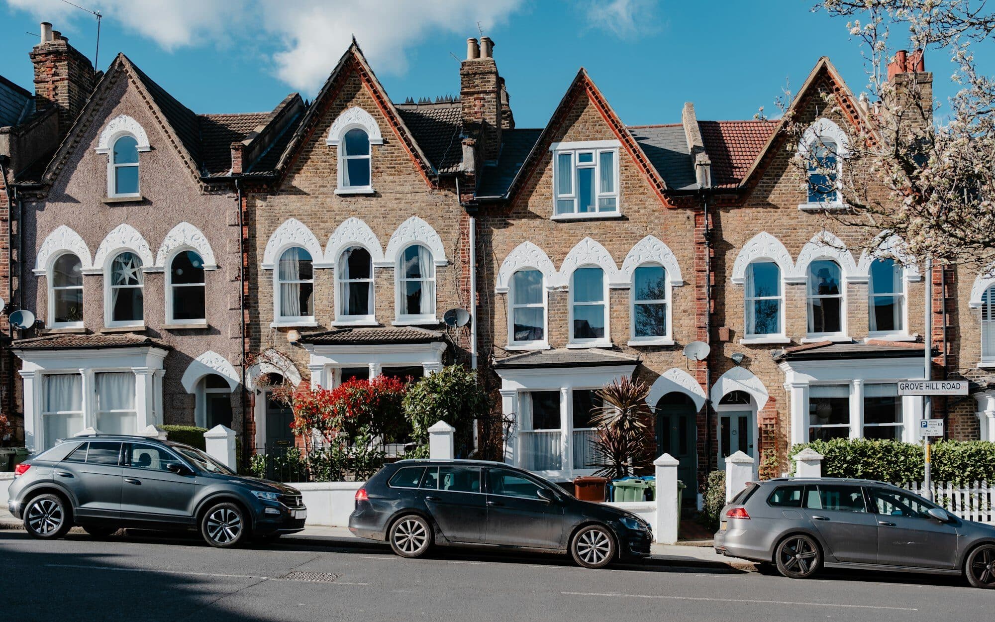 Red-brick Victorian terraced houses with bay and sash windows on a British residential street