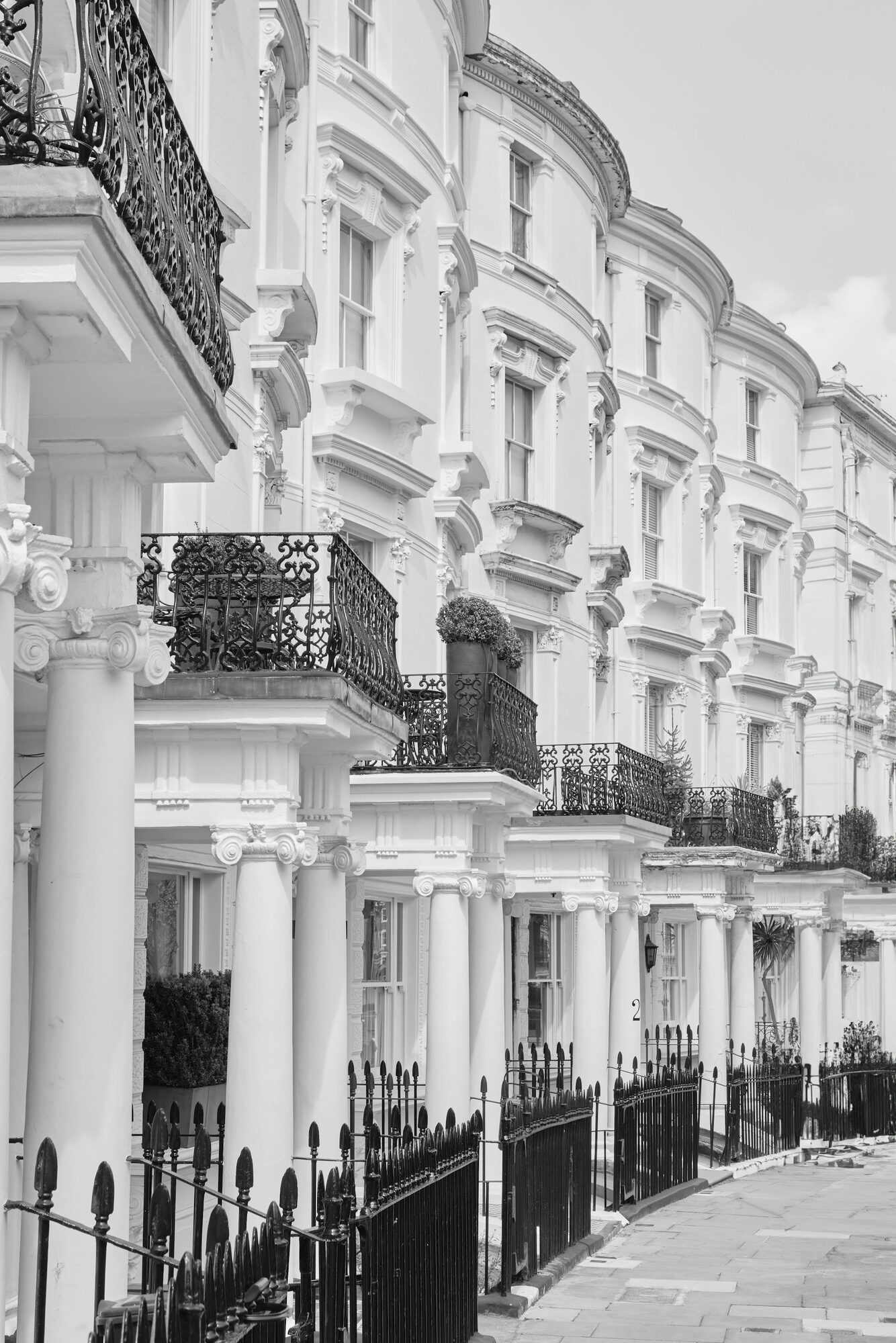 White Victorian townhouses with ornate stucco facades and black iron balconies